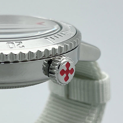 Closeup of crown on silver stainless steel dive watch with X logo