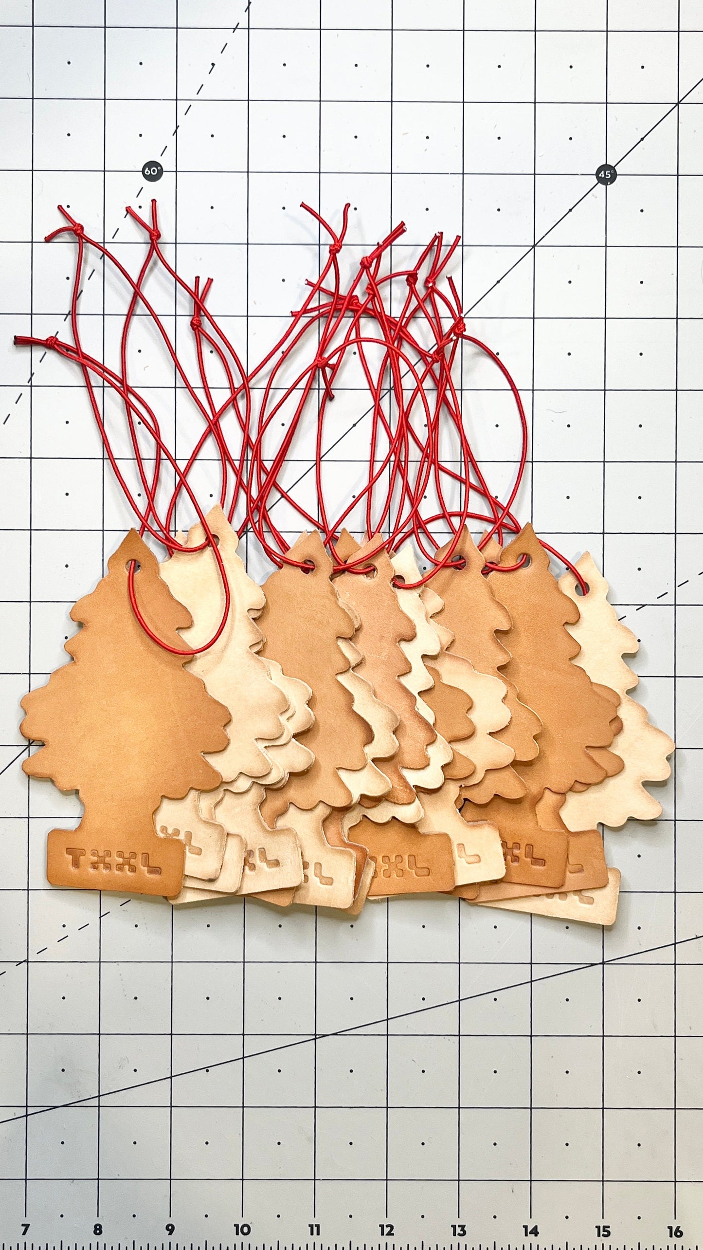 A stack of leather little tree car fresheners with TXXL logos